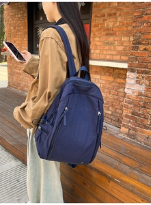 Detail of navy blue waterproof nylon backpack with side pockets and adjustable straps