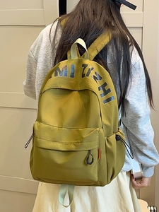 Minimalist olive green travel backpack for women featuring durable nylon and spacious main pocket