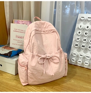 Detail shot of pink ballet style backpack showing nylon texture and bow decoration