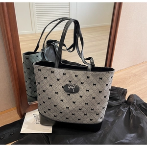 Détail du sac en toile grise avec imprimé nœud noir et base en cuir de haute qualité