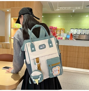 Détail d'un sac à dos en toile aux couleurs contrastées avec de mignons pendentifs
