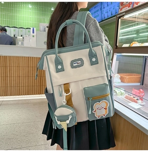 Détail du sac à dos bicolore crème et vert avec pochette ronde et patch décoratif