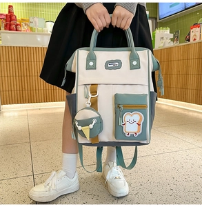 Détail d'un sac à dos en toile multicolore avec poche toast et mini pendentif rond