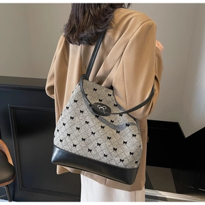 Vue détaillée du dos d'un sac seau gris à motifs nœuds porté par un mannequin