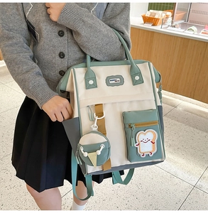 Détail d'un sac à dos en toile bicolore avec broderie toast et pendentif glace