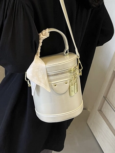 Sac cylindrique blanc élégant avec foulard floral et détails métalliques dorés
