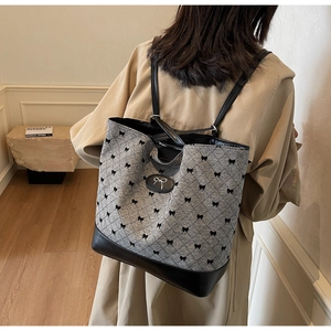 Détails de dos d'un sac cabas en jacquard gris avec motifs nœuds noirs et base en cuir
