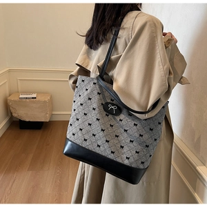 Détail du sac fourre-tout gris à losanges avec motifs de nœuds noirs et touches de cuir