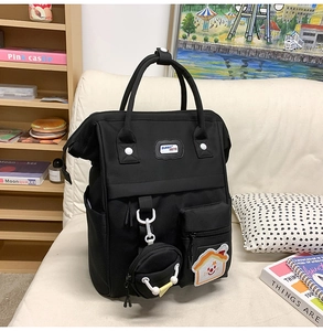 Gros plan du sac à dos en toile noire avec patch BUNNY METE et pendentif porte-monnaie