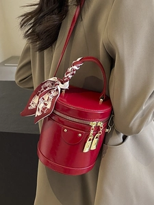Sac cylindrique rouge foncé élégant avec poignée en foulard et détails de serrure dorée