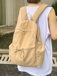 Minimalist beige ballet style nylon backpack with drawstring pocket and wide straps