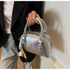 Silver metallic bowling bag featuring a baseball charm and high-gloss leather texture