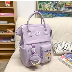Vue détaillée du sac à dos lavande imperméable avec petit porte-monnaie et patch mignon
