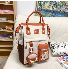 Gros plan sur le sac à dos tricolore avec étiquette Bunny Mete et pochette ronde suspendue