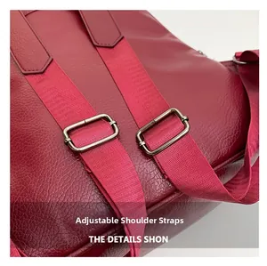 Detail view of adjustable shoulder strap with silver buckle on red lychee texture bag