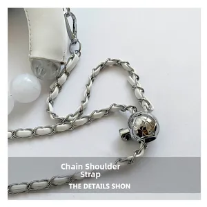 Détail de la bandoulière en cuir blanc avec perle marbrée et boucle à bille argentée