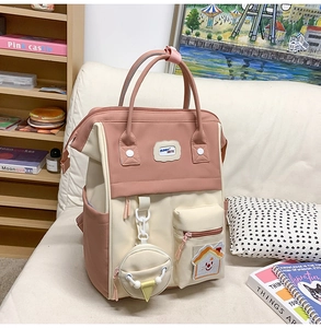 Détail du sac à dos rose et beige avec badge Bunny Mete et petit porte-monnaie arrondi