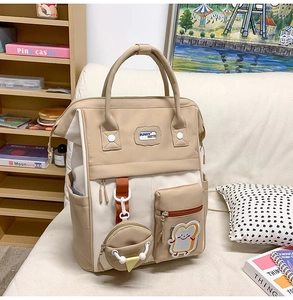 Détail d'un sac à dos contrasté avec breloque toast cartoon et étiquette bunny