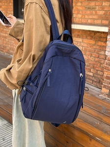 Navy blue minimalist large capacity nylon backpack with long decorative ribbon zippers