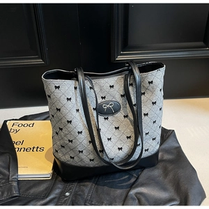 Détail de l'imprimé nœud et du motif matelassé sur le sac seau gris élégant