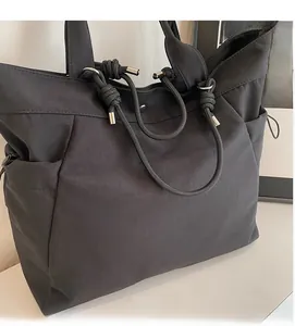 Detailed close-up of a black tote bag showing rope handles and durable nylon fabric