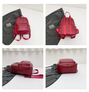 Detail view of red faux leather backpack featuring silver rivets and metal cross emblem