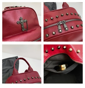 Detail of red textured leather backpack with metal studs and silver cross pendant