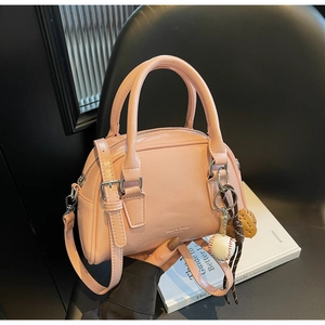 Detailed macro of pink Boston bag with brand embossing and creative baseball charm