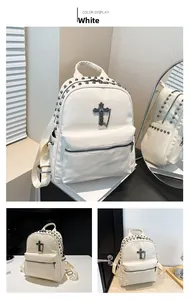 Detail view of white lychee leather backpack with metal rivets and cross pendant