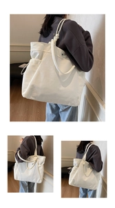 Detail of high-density white canvas tote bag featuring knotted straps and side pockets
