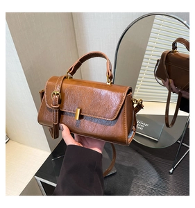 Detail der braunen Vintage-Handtasche aus Öl-Wachs-Leder mit goldener Schnalle und Griff