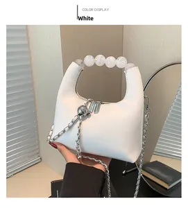 Gros plan du sac bandoulière blanc avec poignée en perles et chaîne argentée