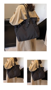 Detail of black canvas tote bag showing side pockets and knot decor with metal rings