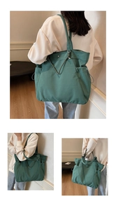 Detail of green canvas tote bag showing drawstring closure and side pocket on shoulder bag