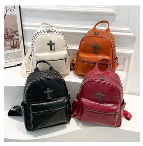 Detailed view of punk style mini backpacks featuring metallic rivets and silver cross charms