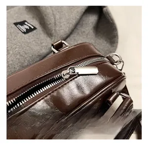 Gros plan détaillé sur la fermeture éclair en métal argenté du sac marron en cuir PU