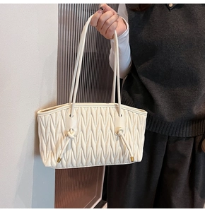 Detail of off-white pleated shoulder bag with soft leather texture and knot metal accents
