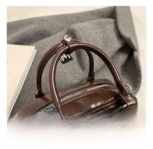 Vue détaillée du sac à main en cuir marron avec doubles poignées et détails argentés