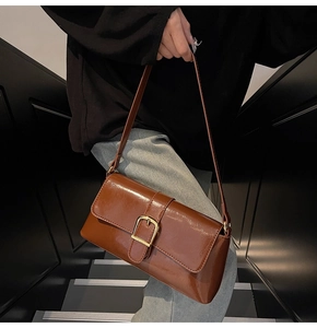 Détail du sac baguette en cuir marron vintage avec boucle dorée élégante