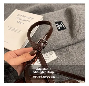 Détail de la bandoulière réglable en similicuir marron foncé avec boucle argentée