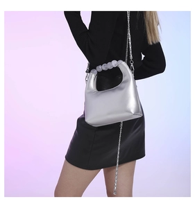 Détail du sac argenté métallisé avec poignée en perles de résine et bandoulière