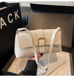 Détail du sac baguette blanc cassé avec boucle dorée et texture cuir de qualité
