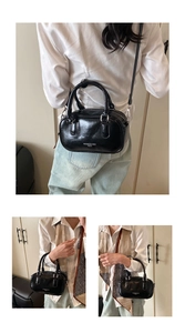 Vue détaillée du sac Boston noir brillant avec logo blanc et bandoulière amovible