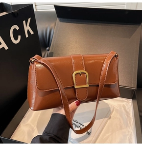 Détail du sac baguette en cuir verni marron caramel avec boucle carrée dorée élégante