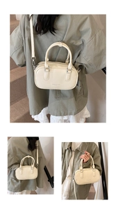 Vue détaillée du sac Boston crème avec doubles poignées et bandoulière réglable