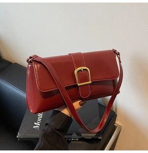 Détail du sac baguette bordeaux avec texture en similicuir et boucle dorée