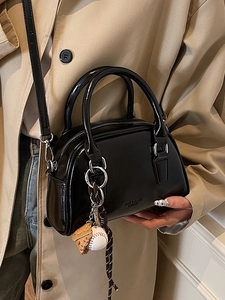 Glossy black vintage bowling bag with sport charms and a detachable leather shoulder strap