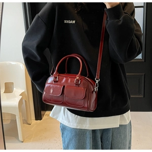 Mirror selfie showing a burgundy wax leather Boston bag with dual front flap pockets