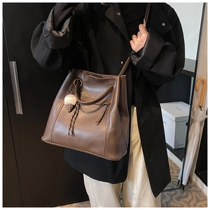 Borsa a secchiello minimalista marrone scuro in pelle con dettaglio pompon morbido