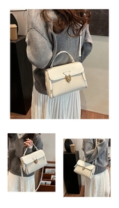 Detailaufnahme der cremeweißen Handtasche mit goldenem Vintage-Dreieck Metallverschluss